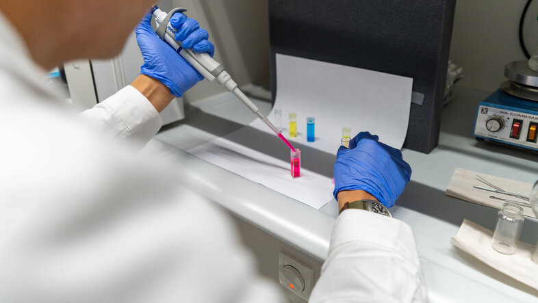 A scientist pipetting colourful liquids